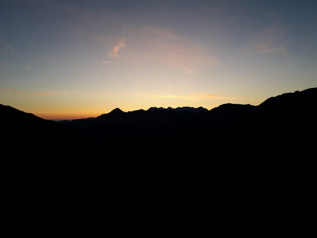 Montagnes noires et horizon orangé au crépuscule