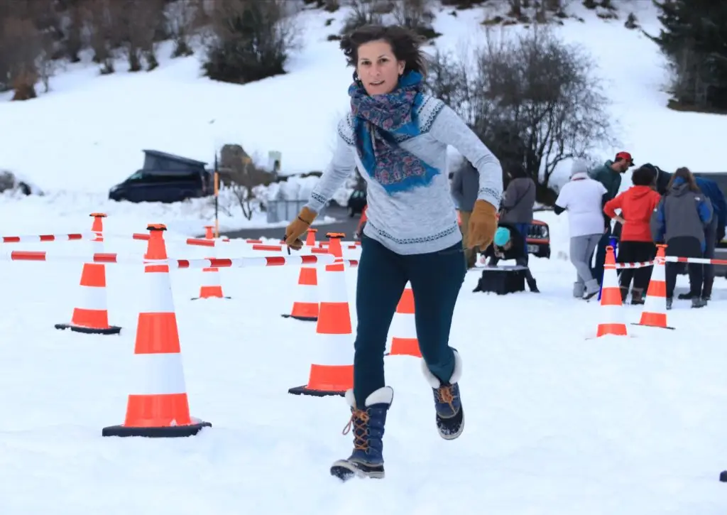 Femme courant dans la neige en jouant au Learn-O dans le Val d'Azun