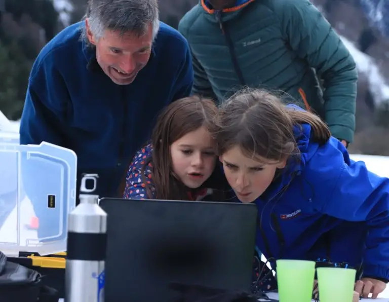 Famille regardant l'ordinateur pour obtenir les résultats du jeu d'orientation Learn-O