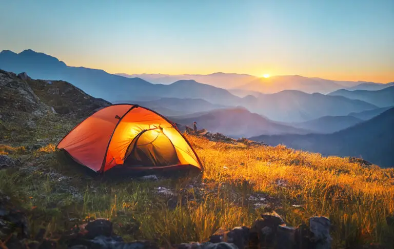 Tente de bivouac ensoleillée au coucher de soleil en montagne