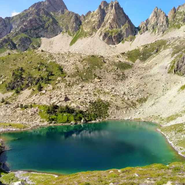 Lac de montagne aux eaux turquoise niché au cœur des Pyrénées, entouré de sommets rocheux – paysage typique d’une randonnée dans les Hautes-Pyrénées.