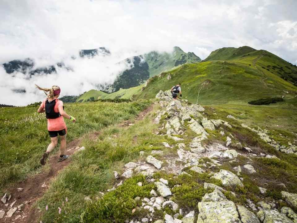Couple de traileurs courant sur un sentier de montagne trail dans les Pyrénées Gavarnie