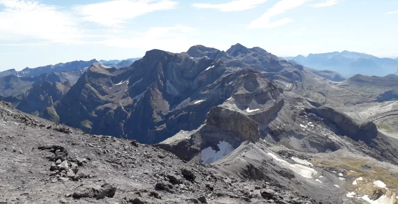 Vue depuis le Taillon sur le Pic du Marboré et le Mont Perdu avec un ciel dégagé, roches et quelques névés accrochés